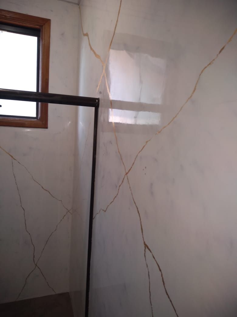 Parede de box em marmorato branco e dourado com janela de madeira