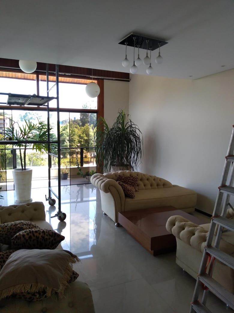 Sala de estar ampla com paredes cor de creme recém-pintadas e janelões, obra do Shamir Marmorato